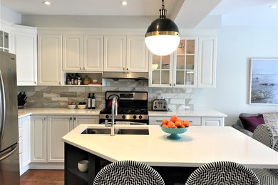 Example of a small trendy l-shaped medium tone wood floor and brown floor kitchen design in Toronto with an undermount sink, raised-panel cabinets, white cabinets, quartzite countertops, white backsplash, marble backsplash, stainless steel appliances, an island and white countertops