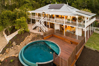 Inspiration for a traditional two-storey white house exterior in Sunshine Coast with a metal roof.