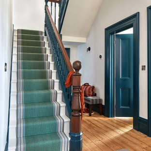 Immagine di un ingresso o corridoio minimal di medie dimensioni con pareti bianche, moquette e pavimento verde