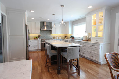 Example of a large transitional u-shaped light wood floor kitchen design in Cincinnati with a double-bowl sink, recessed-panel cabinets, white cabinets, quartz countertops, blue backsplash, porcelain backsplash, stainless steel appliances and an island