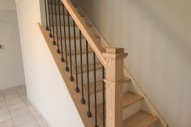 Modelo de escalera recta actual de tamaño medio con escalones de madera, contrahuellas de madera y barandilla de varios materiales