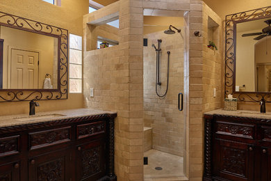 Inspiration for a large mediterranean master bathroom in Other with furniture-like cabinets, dark wood cabinets, an alcove shower, beige walls, an undermount sink, beige floor, a hinged shower door and beige benchtops.