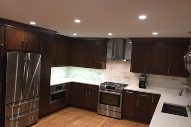 Example of a mid-sized trendy u-shaped eat-in kitchen design in Atlanta with flat-panel cabinets, medium tone wood cabinets, granite countertops, white backsplash and white countertops