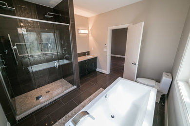 Example of a mid-sized minimalist master porcelain tile bathroom design in Edmonton with shaker cabinets, dark wood cabinets, a two-piece toilet, beige walls, an undermount sink and granite countertops