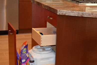 Mid-sized trendy galley porcelain tile eat-in kitchen photo in San Diego with a drop-in sink, flat-panel cabinets, light wood cabinets, granite countertops, glass tile backsplash, stainless steel appliances and an island