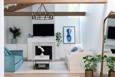 Mid-sized vaulted ceiling living room photo in San Francisco with white walls, a standard fireplace, a stone fireplace and a wall-mounted tv