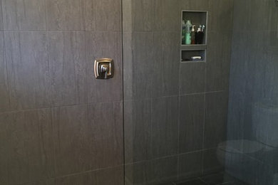 Trendy master gray tile and porcelain tile porcelain tile doorless shower photo in Omaha with shaker cabinets, white cabinets, a two-piece toilet, an undermount sink and marble countertops