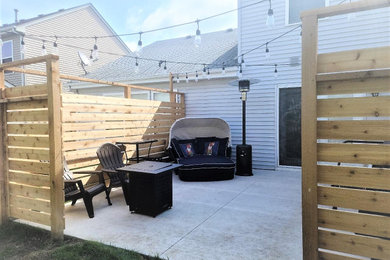This is an example of a large modern backyard patio in Chicago with concrete slab and no cover.