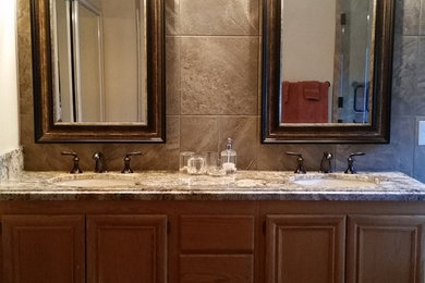 Mid-sized elegant master beige tile and porcelain tile vinyl floor and brown floor alcove bathtub photo in Las Vegas with beaded inset cabinets, brown cabinets, a one-piece toilet, beige walls, an undermount sink, granite countertops, brown countertops and a hinged shower door