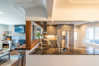 Eat-in kitchen - mid-sized contemporary u-shaped dark wood floor and brown floor eat-in kitchen idea in Denver with an undermount sink, shaker cabinets, blue cabinets, granite countertops, white backsplash, ceramic backsplash, stainless steel appliances and multicolored countertops