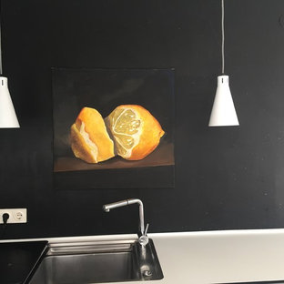 Новые идеи обустройства дома: маленькая кухня в современном стиле с обеденным столом, белыми фасадами, черным фартуком, фартуком из сланца и бетонным полом