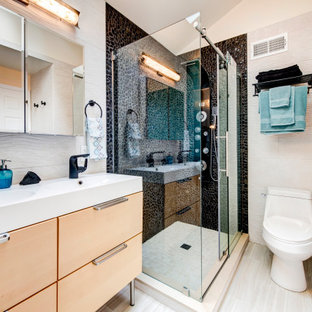 Idée de décoration pour une salle de bain principale design de taille moyenne avec un placard à porte plane, des portes de placard en bois clair, une baignoire en alcôve, une douche d'angle, un WC à poser, un carrelage multicolore, une plaque de galets, un mur multicolore, un sol en carrelage de porcelaine, un lavabo intégré, un plan de toilette en surface solide, une cabine de douche à porte battante et un plan de toilette blanc.