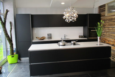 Küche mit schwarzen Schränken, Küchenrückwand in Weiß, Glasrückwand, Küchengeräten aus Edelstahl und Kücheninsel in Nürnberg