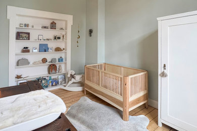 高級な小さなおしゃれな赤ちゃん部屋 (緑の壁、淡色無垢フローリング、男女兼用、ベージュの床) の写真