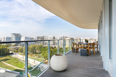 Idées déco pour une terrasse latérale et au premier étage contemporaine de taille moyenne avec un foyer extérieur et un garde-corps en verre.