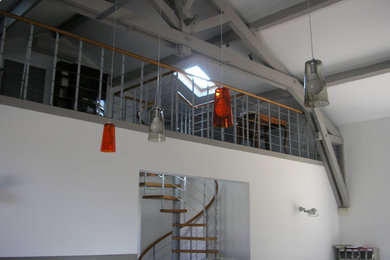 Réalisation d'un escalier sans contremarche hélicoïdal champêtre de taille moyenne avec des marches en bois et un garde-corps en matériaux mixtes.