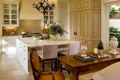 Inspiration for a mid-sized traditional l-shaped eat-in kitchen in San Francisco with an undermount sink, raised-panel cabinets, beige cabinets, marble benchtops, beige splashback, stone slab splashback, panelled appliances, travertine floors and with island.