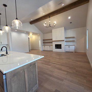 Open area features the chandelier, gas fireplace, custom cabinets & floating she