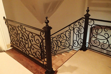 Diseño de escalera clásica de tamaño medio con escalones de madera, contrahuellas de madera y barandilla de metal