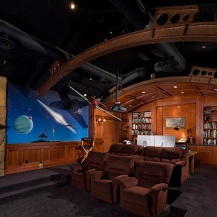 Enclosed home cinema in Santa Barbara with multi-coloured walls, carpet, a projector screen and black floors.