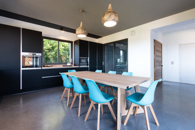 Réalisation d'une très grande cuisine design en L fermée avec un évier posé, un placard à porte affleurante, des portes de placard noires, un plan de travail en stratifié, une crédence beige, un électroménager en acier inoxydable, sol en béton ciré, aucun îlot, un sol gris, un plan de travail beige et un plafond décaissé.