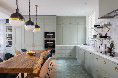 Photo of a mid-sized eclectic l-shaped eat-in kitchen in London with an undermount sink, recessed-panel cabinets, grey cabinets, grey splashback, stainless steel appliances, no island, beige floor and white benchtop.
