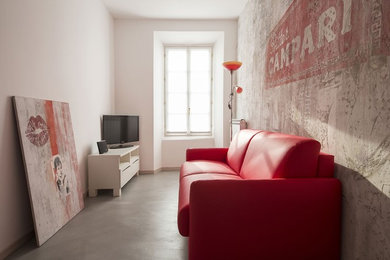 This is an example of a small contemporary enclosed living room in Milan with multi-coloured walls, concrete floors, no fireplace, a freestanding tv and grey floor.
