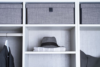 This is an example of a large contemporary men's walk-in wardrobe in Dallas with flat-panel cabinets, grey cabinets and dark hardwood floors.