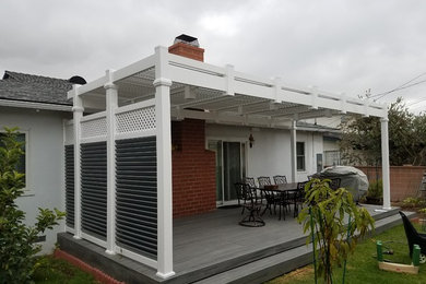 Mid-sized elegant backyard patio photo in Los Angeles with decking and a pergola