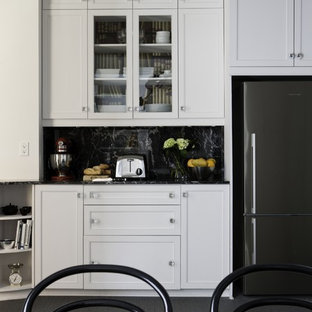 На фото: маленькие отдельные кухни в викторианском стиле с одинарной раковиной, белыми фасадами, столешницей из гранита, черным фартуком, фартуком из каменной плитки, техникой из нержавеющей стали и ковровым покрытием без острова