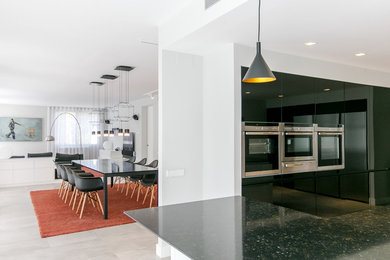 Large contemporary open plan dining in Barcelona with grey walls, porcelain floors and grey floor.