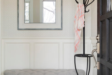Example of a small classic porcelain tile and brown floor entryway design in Minneapolis with beige walls and a black front door