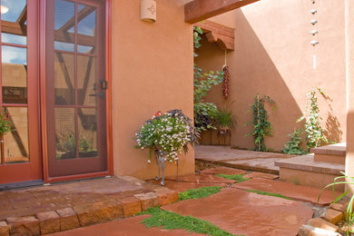 This is an example of a large courtyard partial sun formal garden for spring in Albuquerque with a garden path and brick pavers.