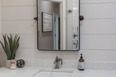 Bathroom - cottage white tile and subway tile bathroom idea in Tampa with furniture-like cabinets, medium tone wood cabinets, quartz countertops, white countertops and an undermount sink