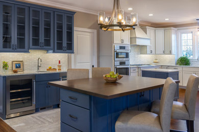 Design ideas for a large traditional kitchen with a submerged sink, recessed-panel cabinets, blue cabinets, wood worktops, grey splashback, limestone splashback, dark hardwood flooring, brown floors and brown worktops.