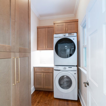 Compact Laundry Room with Stacked Washer Dryer and Custom Cabinetry