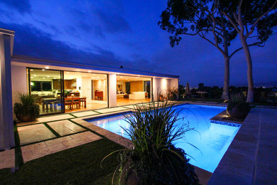 Pool fountain - mid-sized contemporary backyard stamped concrete and custom-shaped lap pool fountain idea in Los Angeles