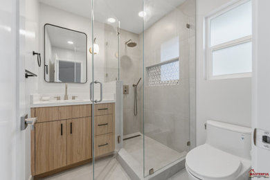 Example of a minimalist master white tile single-sink alcove shower design in San Francisco with flat-panel cabinets, beige cabinets, a hinged shower door and white countertops