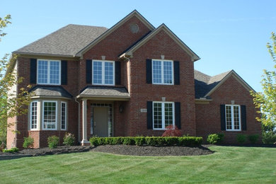 Inspiration for a large timeless red two-story brick exterior home remodel in Detroit