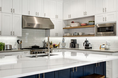 Open concept kitchen - large contemporary l-shaped medium tone wood floor and brown floor open concept kitchen idea in Tampa with an undermount sink, recessed-panel cabinets, white cabinets, quartz countertops, white backsplash, subway tile backsplash, stainless steel appliances, an island and gray countertops