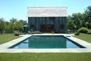 Large country backyard rectangular lap pool in New York with tile.