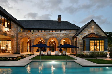 Mid-sized elegant beige two-story stone exterior home photo in Houston with a tile roof and a black roof