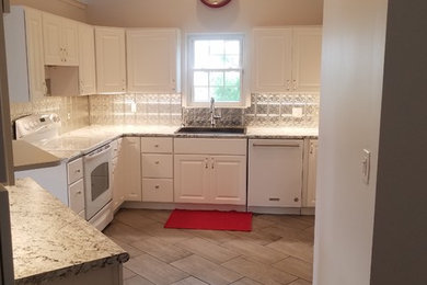 Inspiration for a mid-sized transitional u-shaped porcelain tile and gray floor kitchen remodel in Cincinnati with a drop-in sink, raised-panel cabinets, white cabinets, laminate countertops, metallic backsplash, metal backsplash, white appliances, no island and gray countertops