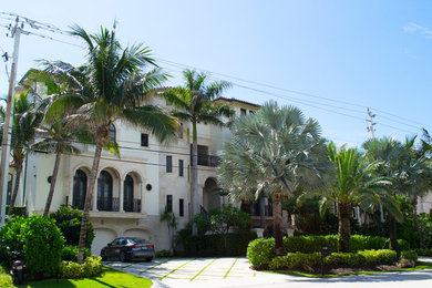 Example of a huge tuscan beige three-story mixed siding exterior home design in Miami with a tile roof