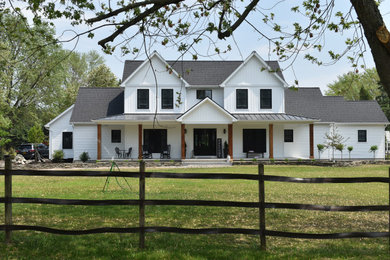 Example of a large transitional white two-story vinyl and board and batten exterior home design in New York with a mixed material roof and a gray roof
