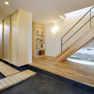 他の地域のアジアンスタイルのおしゃれな玄関 (白い壁、グレーの床) の写真