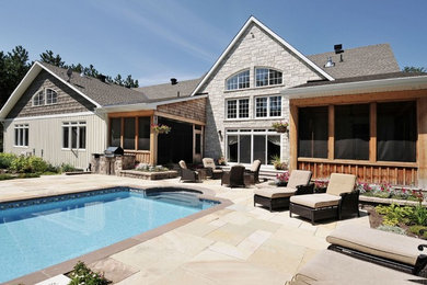 Mid-sized arts and crafts backyard stone and rectangular lap pool photo in Other