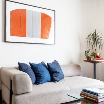 Home Styling: Beige Sofa with Vibrant Orange Artwork and Blue Cushions - Eclecti