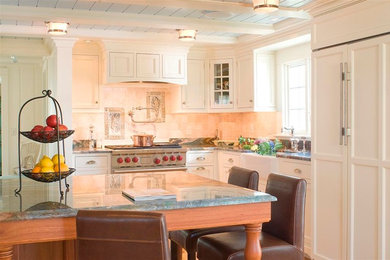 Inspiration for a mid-sized beach style l-shaped open plan kitchen in Portland Maine with a farmhouse sink, recessed-panel cabinets, white cabinets, beige splashback, ceramic splashback, light hardwood floors and with island.