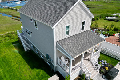 Example of a large beach style gray two-story wood and shingle exterior home design in Boston with a shingle roof and a gray roof